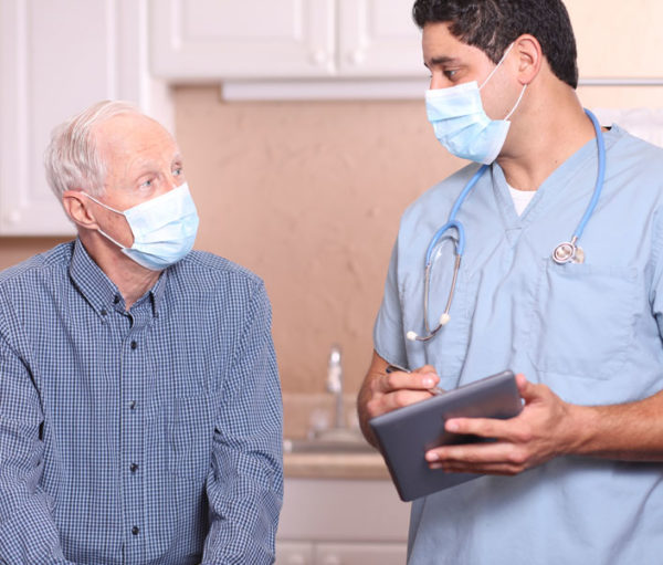 Nurse and patient wearing masks and talking